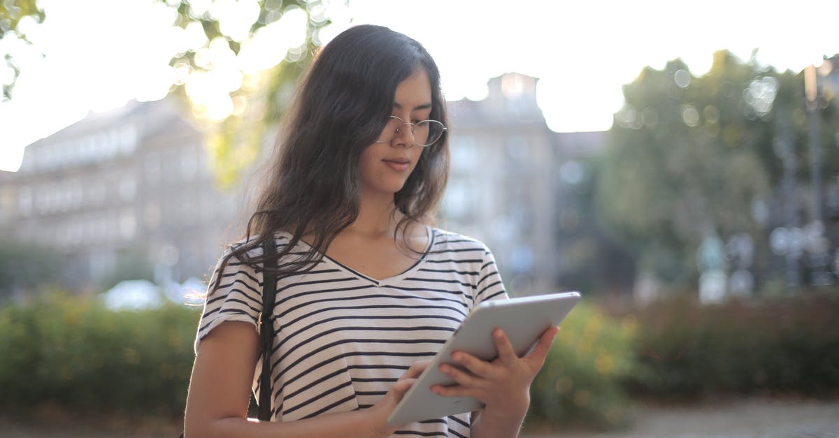 How should I use extra summer squash? - Calm pensive female freelancer using digital tablet on street