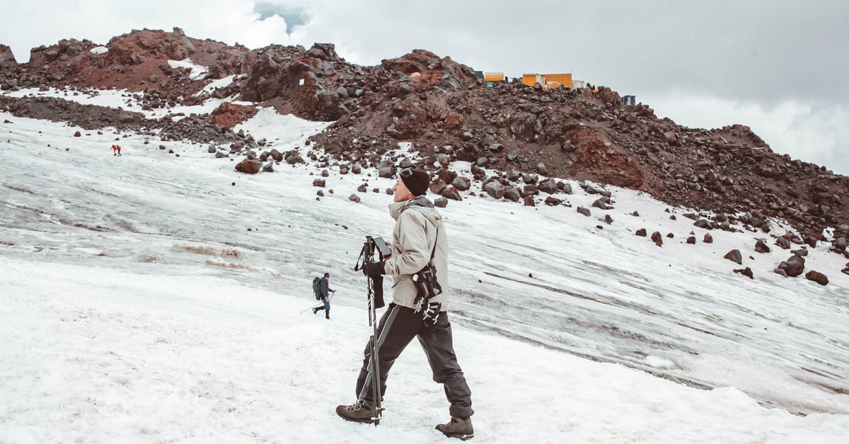 How to achieve a flexible consistency on ice cream? (photos attached) - Full body of male traveler in warm outerwear walking with trekking sticks on snowy mountain ridge in daytime