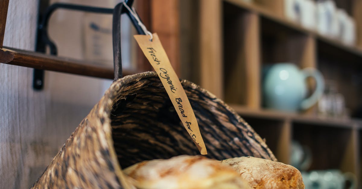 How to achieve great baguette crusts - Fresh tasty organic bread in wicker bucket hanging from metal hook in traditional bakery