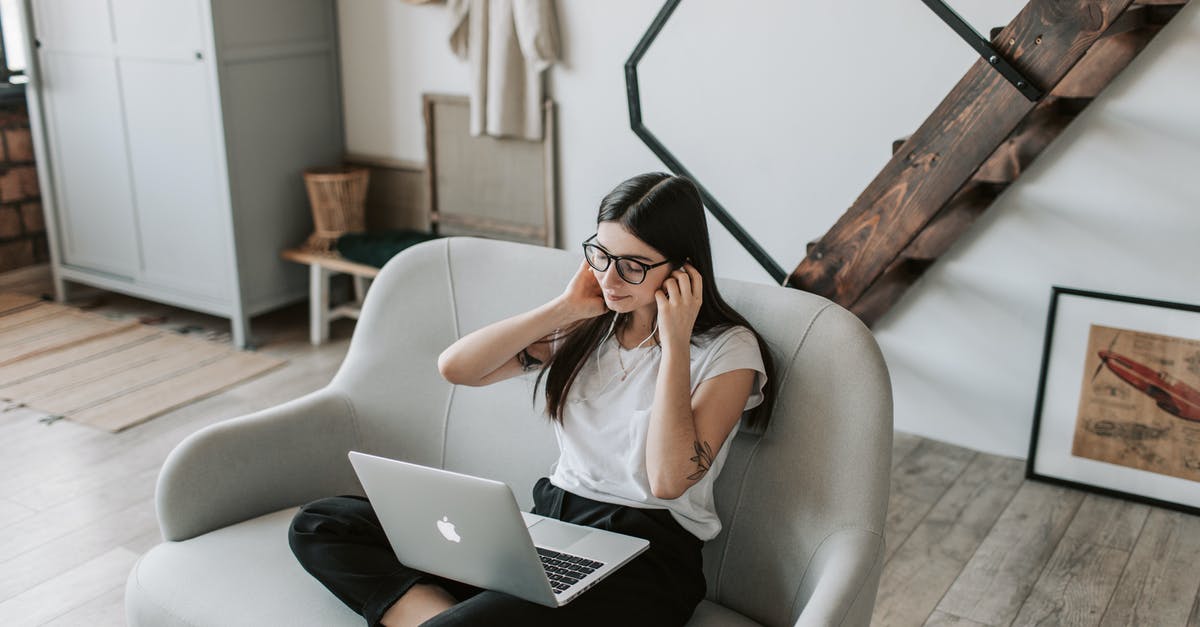 How to adjust time for oven stuck at 350F - Positive woman using earphones and laptop at home during free time