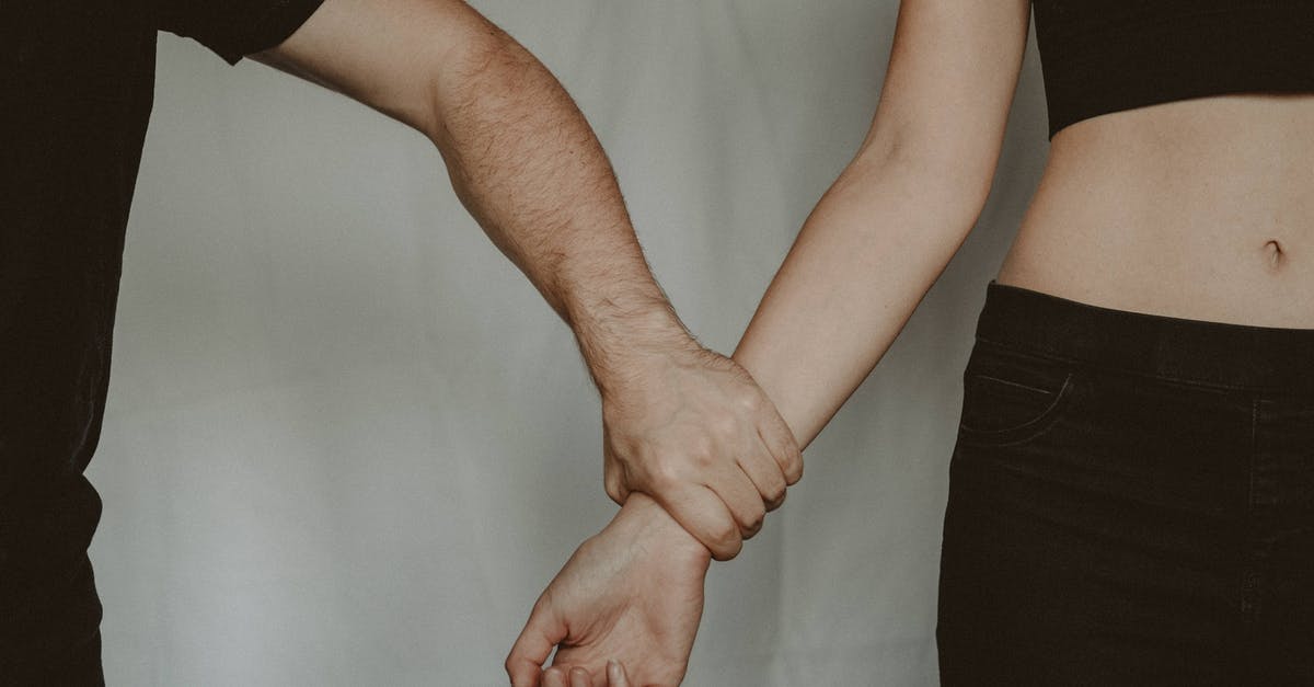 How to avoid/overcome seized tahini - Unrecognizable aggressive man seizing hand of vulnerable helpless woman while standing on white background during domestic violence in light room