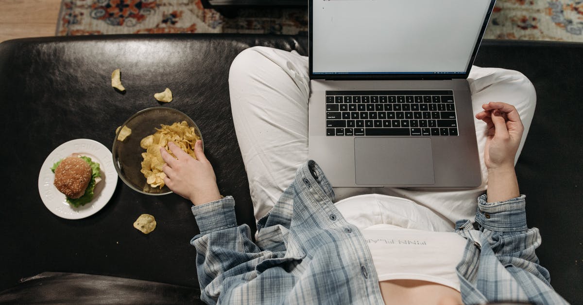 How to bake chips in microwave using grill? - Overhead Shot of a Person Eating Chips while Using a Laptop