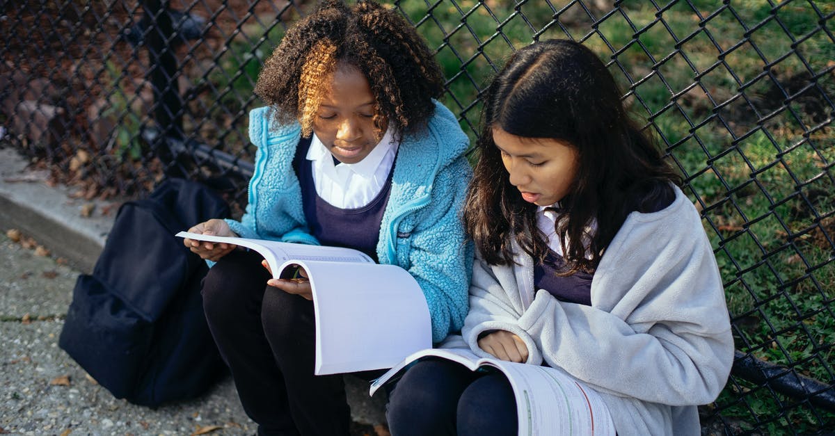 How to best prepare Sukimono - From above concentrated multiracial girls classmates reading article in textbooks while sitting together on ground near net fence in autumn park