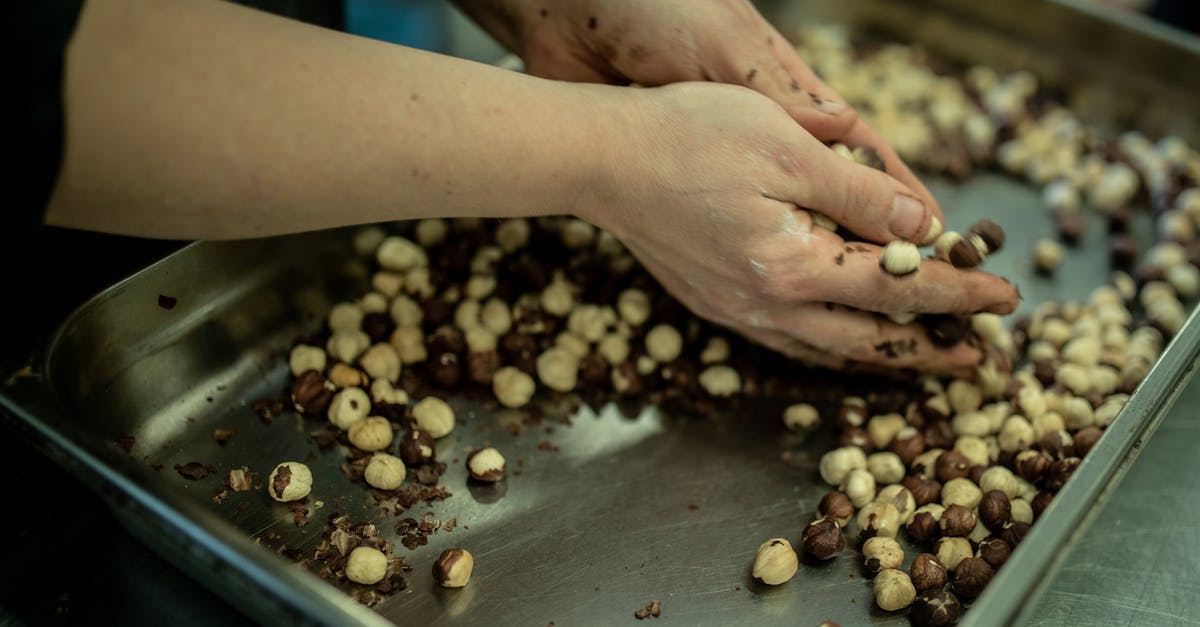 How to blanch and peel nuts? - Crop woman with nuts in kitchen of cafe