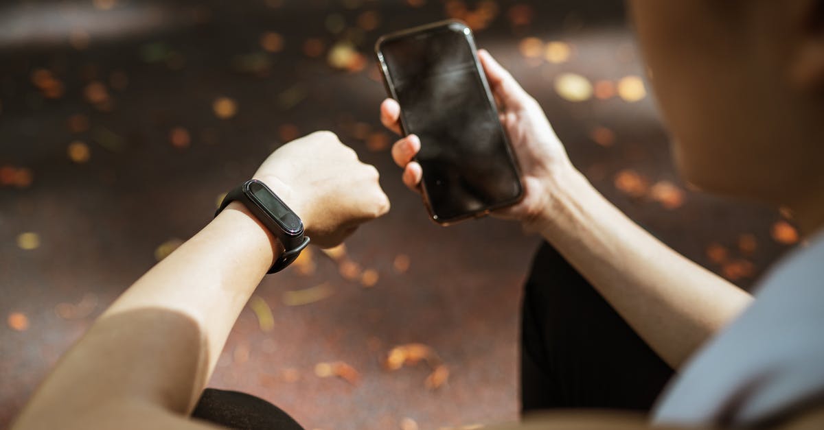 How to check whether the Olive oil is fit for consumption or not? - Back view of anonymous female using smartphone app and smart watch after jogging in park