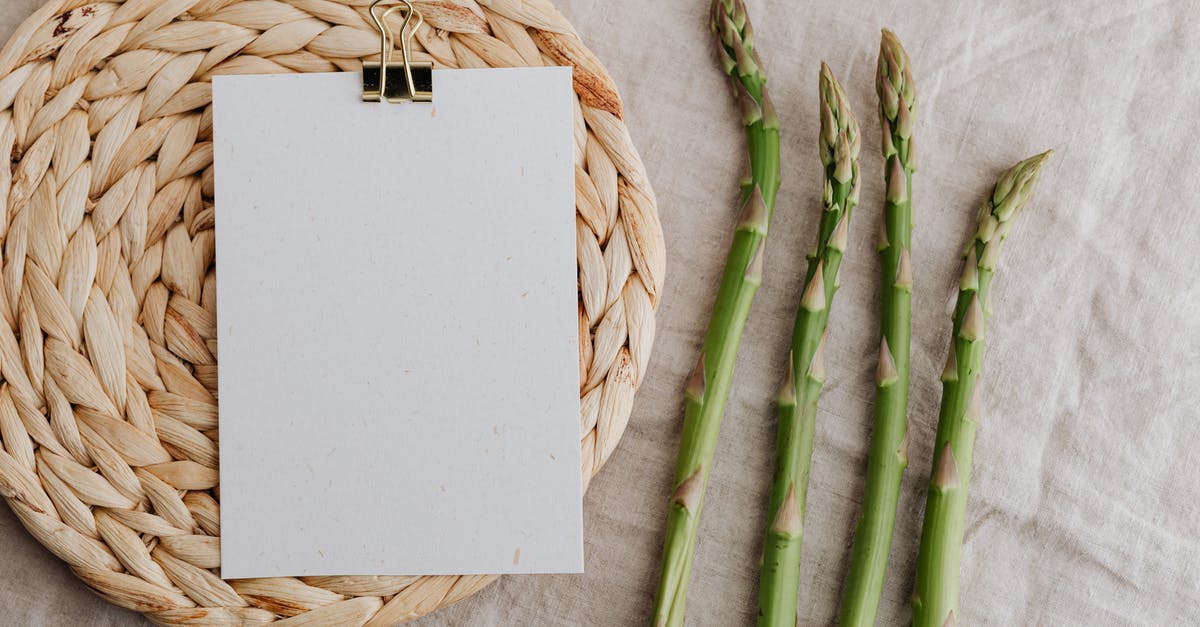 How to clean caked on stains from juicing vegetables? - From above of four fresh green asparagus sprouts and blank sheet of paper over round wicker placemat laid on white tablecloth
