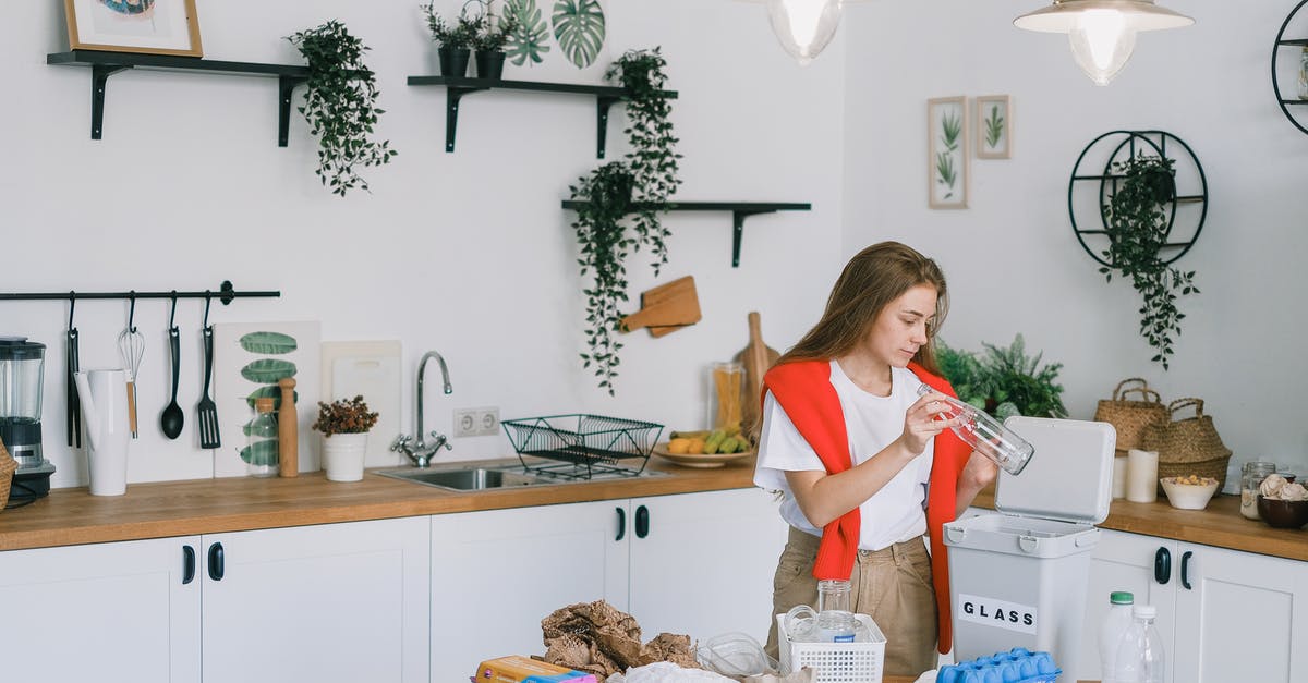 How to clean melted plastic from oven - Young woman utilizing wastes in modern kitchen