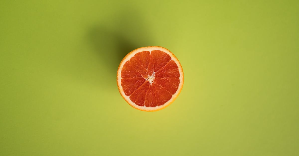How to clean pulp collector of a fruit juice extractor - Slice of grapefruit on green surface