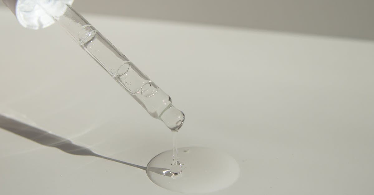 How to clean settled oil fumes from cabinets? - Anonymous person pouring liquid product on table with pipette