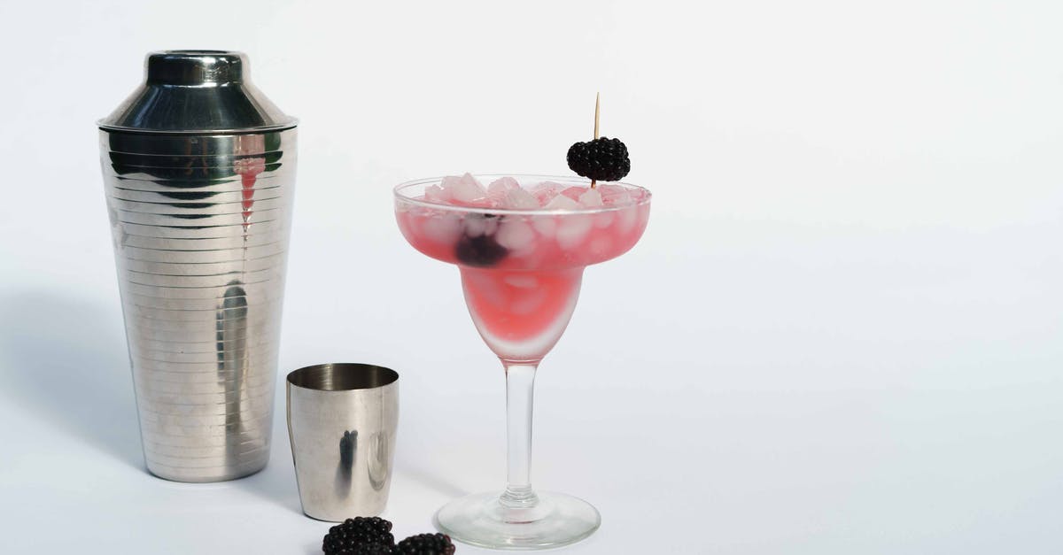 How to clean silicone ice cube forms? - Cold refreshing margarita cocktail made of ice cubes and blackberries placed near shaker on white background