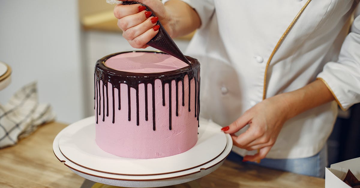 How to convert a chocolate fudge frosting recipe to white chocolate? - Anonymous female pastry chef in white uniform standing near counter and preparing yummy cake with chocolate drips from pastry bag in kitchen