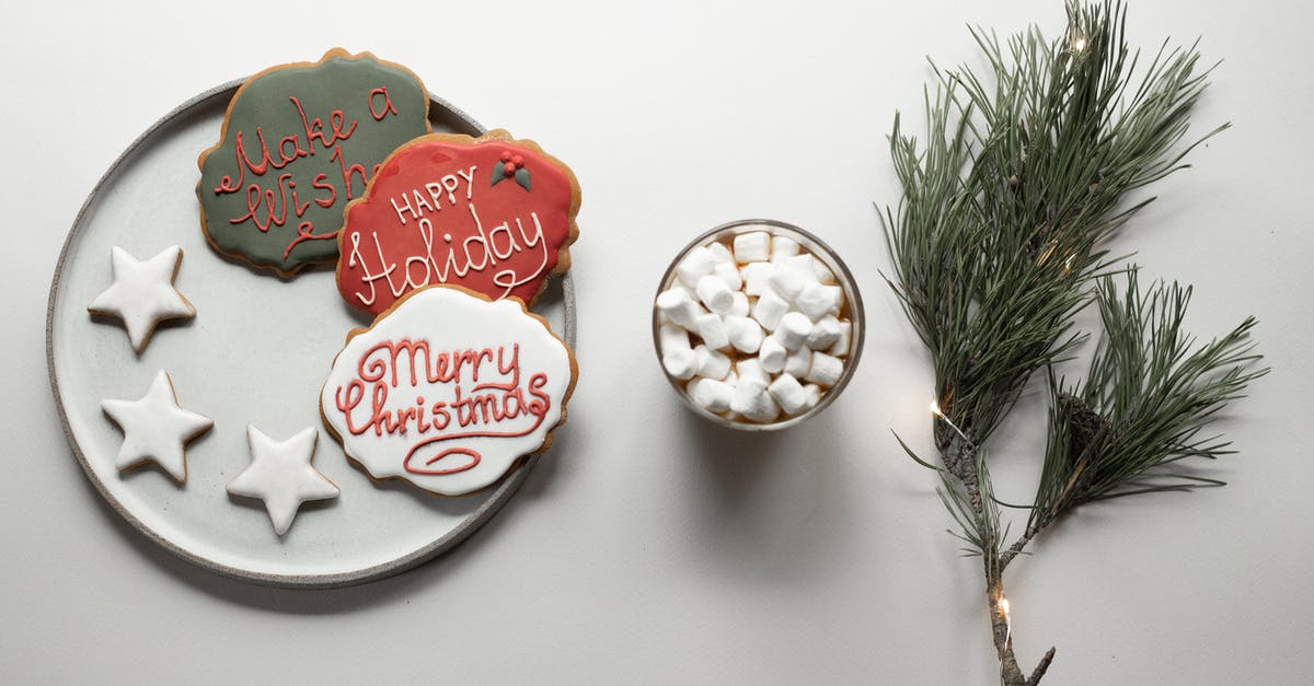 How to convert a chocolate fudge frosting recipe to white chocolate? - Overhead composition of Christmas gingerbread cookies covered with icing placed near hot chocolate with sweet marshmallows and coniferous branch