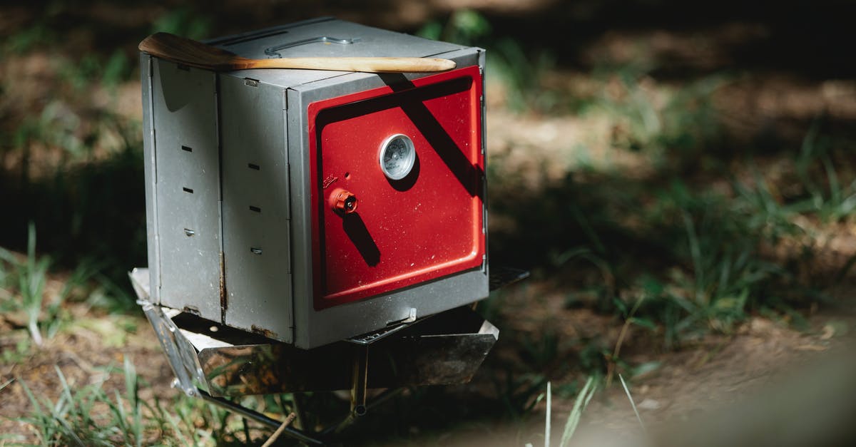 how to cook on a low and high oven - Folding camping oven placed in forest in sunlight