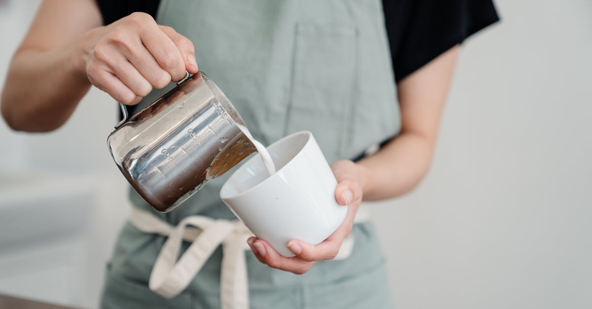 How to declog coffee maker clogged by milk - Crop person pouring milk into cup in kitchen