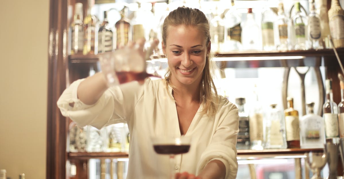 How to determine the alcohol content of a mixed-drink? - Cheerful female bartender pouring cocktail in bar
