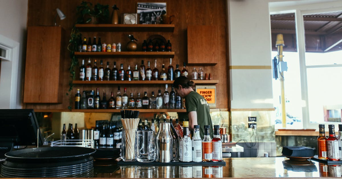 How to do a beer-butt chicken? - Man in Green Shirt Standing in Front of Brown Wooden Shelf