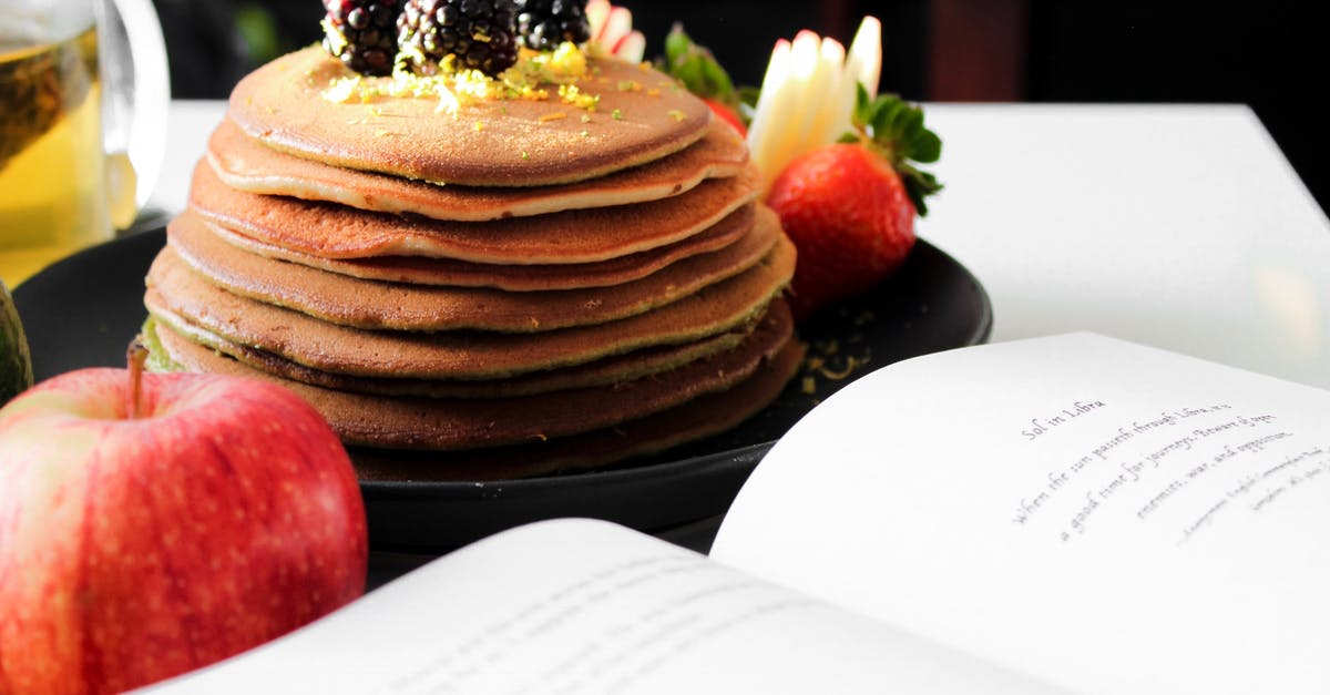 How to draw peanut flavor into rest of dish? - Delicious appetizing pancakes on black plate with blackberries on top and apple near opened book