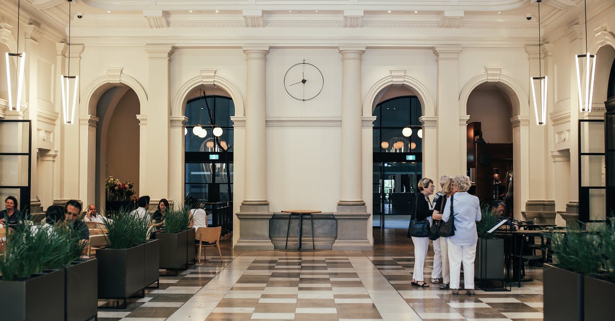 How to eat coconut oil? More details inside! - Group of women standing near menu in spacious restaurant with people eating at tables in contemporary hotel with green vegetation