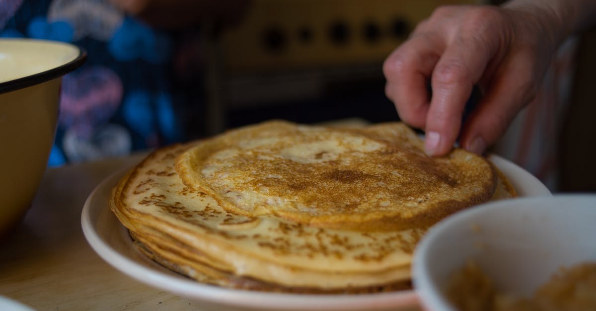 How to ensure that the Pancakes get cooked evenly? - A Person Getting a Pancake on a Plate