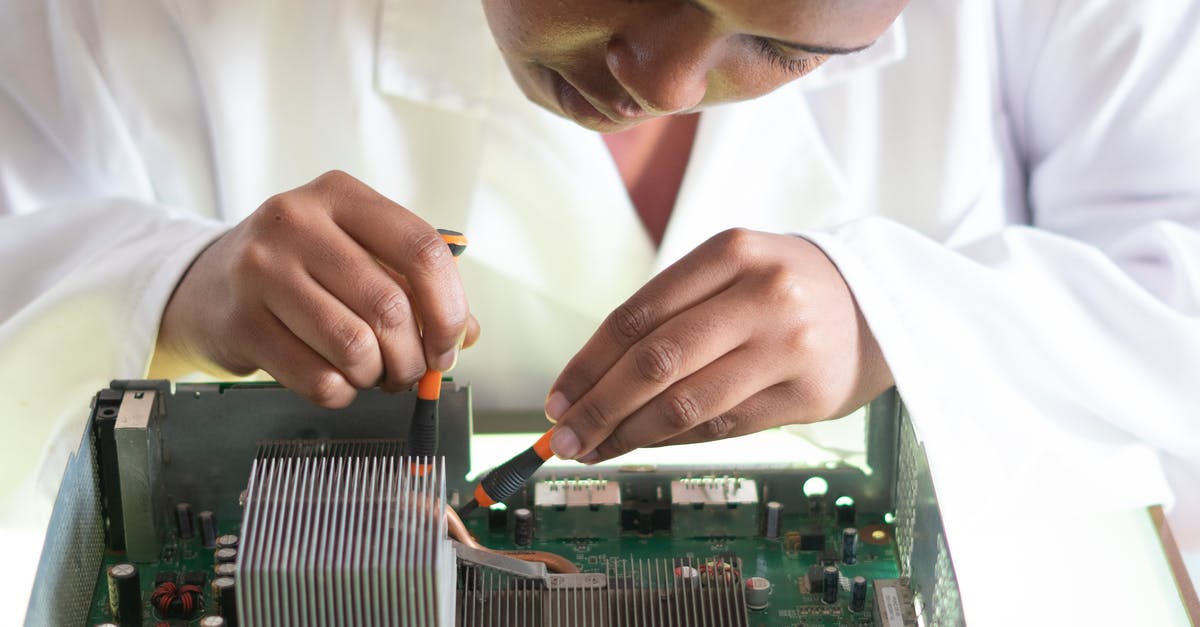 How to fix a bitter jam? (Or use it?) - Concentrated African American technician wearing lab coat and conducting expertise of motherboard by using screwdrivers while working in service center