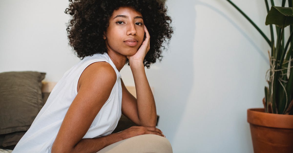 how to freeze individual chicken pot pies - Side view of peaceful African American female with curly hair touching face while resting at home with potted plant