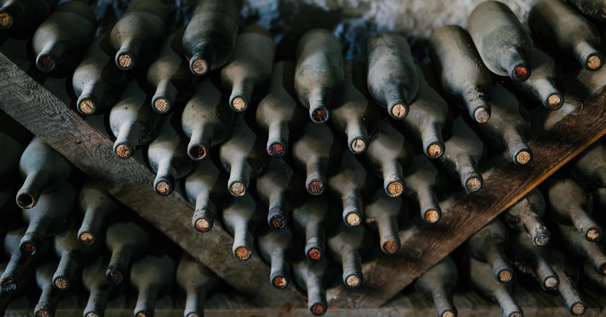 How to get a synthetic cork back in a wine bottle? - From above of dusty bottles of alcohol drink placed above each other in rows in winery How to get a synthetic cork back in a wine bottle? - From above of dusty bottles of alcohol drink placed above each other in rows in winery