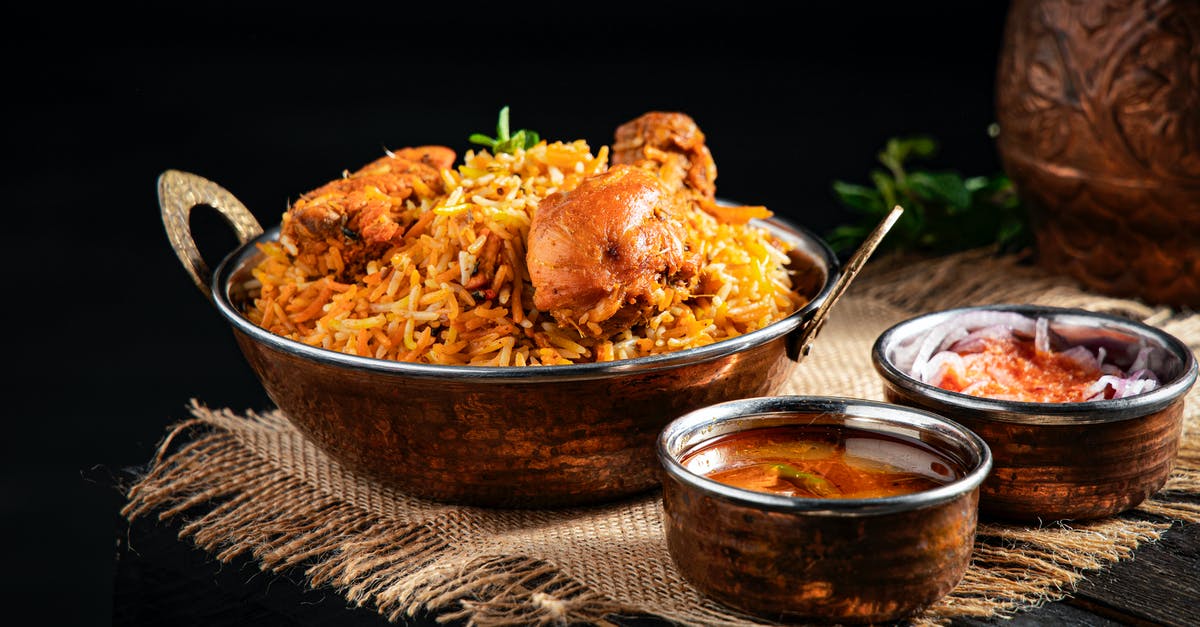 How to get all the rice out of the pan? - From above of delicious pilaf with rice and meat in iron pan served on table near traditional oriental soups in bowl