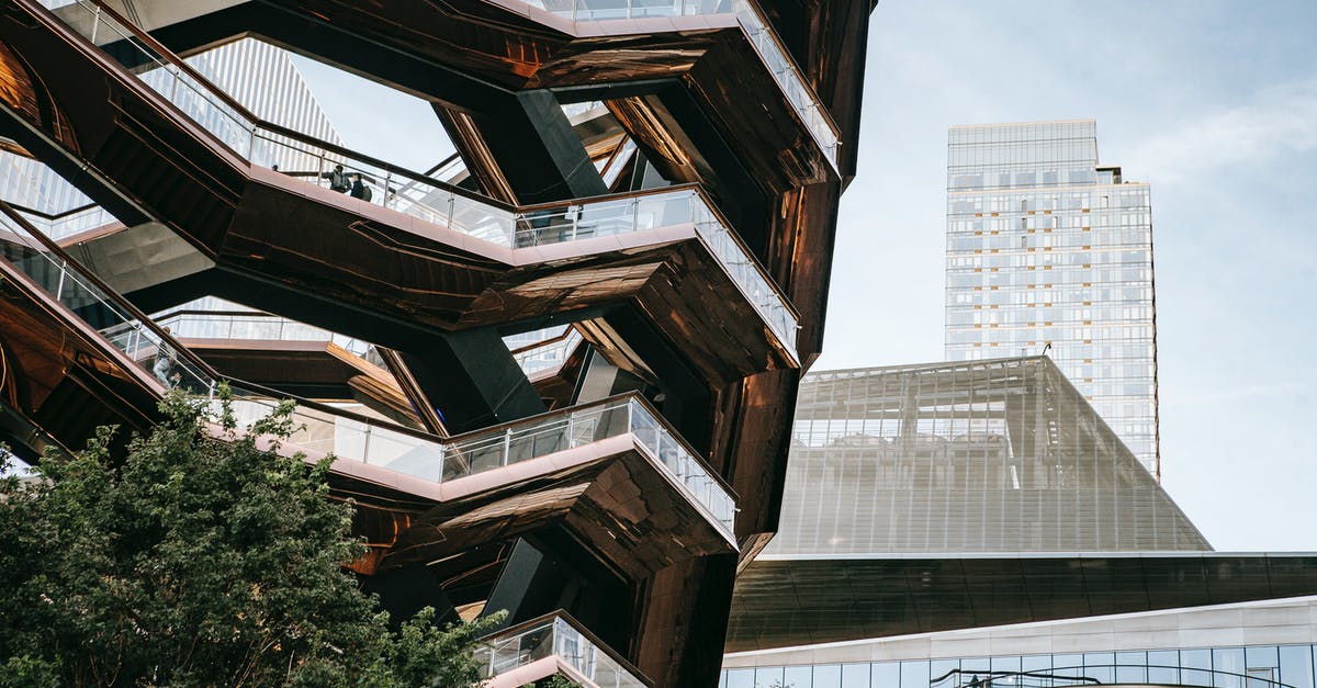 How to get the texture of commercial ketchup? - Low angle of futuristic geometric construction with stairs above bushes in city with skyscrapers in daylight