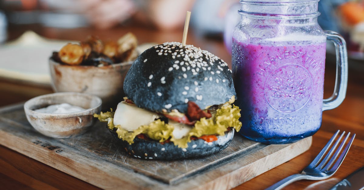 How to grill potatoes? - Delicious hamburger and mug of cold smoothie on wooden board