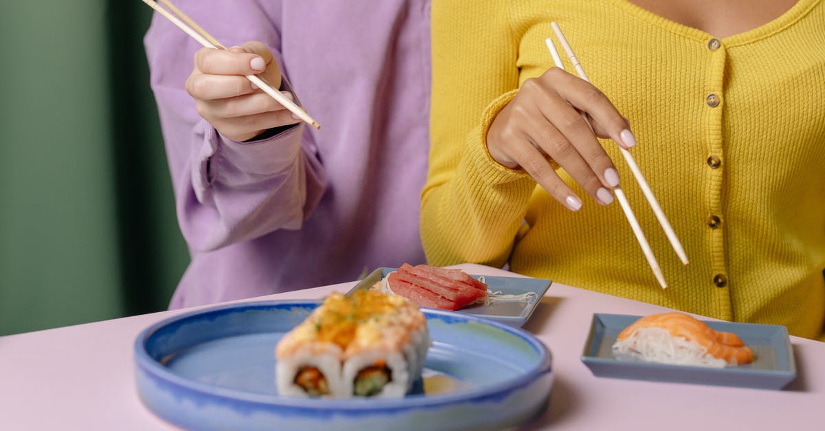 How to hold salmon after cooking for travel to family dinner? - Woman in Yellow Sweater Holding Chopsticks and Eating Food
