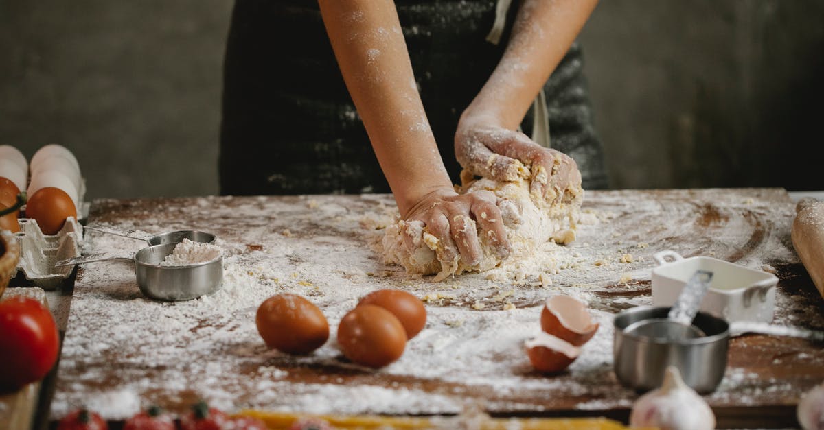 How to judge quantity of fresh pasta dough per person - Crop chef kneading dough on wooden board