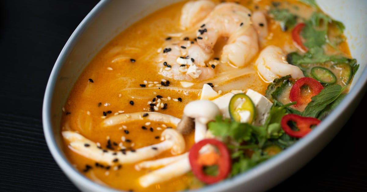 How to keep seasonings from separating in soup - From above of delicious miso soup with funchosa shrimps and mushrooms served with tofu cheese and sliced vegetables decorated with chopped parsley and chili peppers