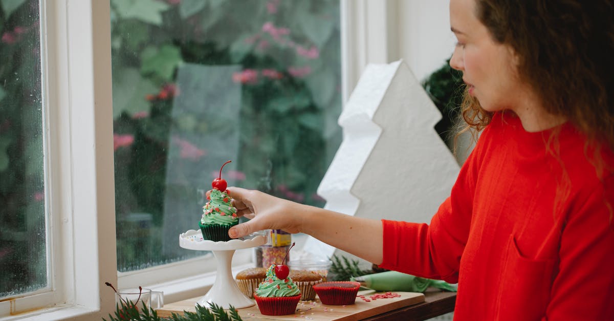 How to make a Cake Jumper? - Side view of young woman in red jumper standing beside window with cupcakes and sprigs of fir tree