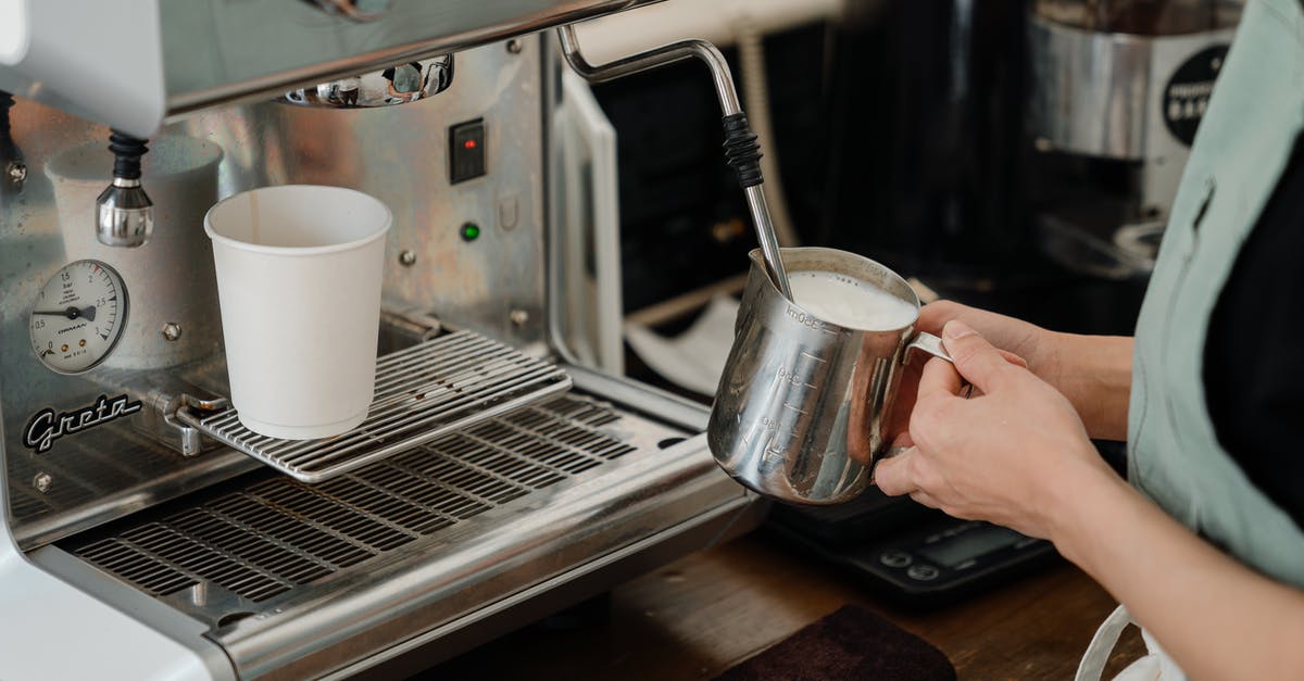 How to make a "French Vanilla cappuccino" with a espresso machine - Crop barista preparing milk for coffee using coffee machine