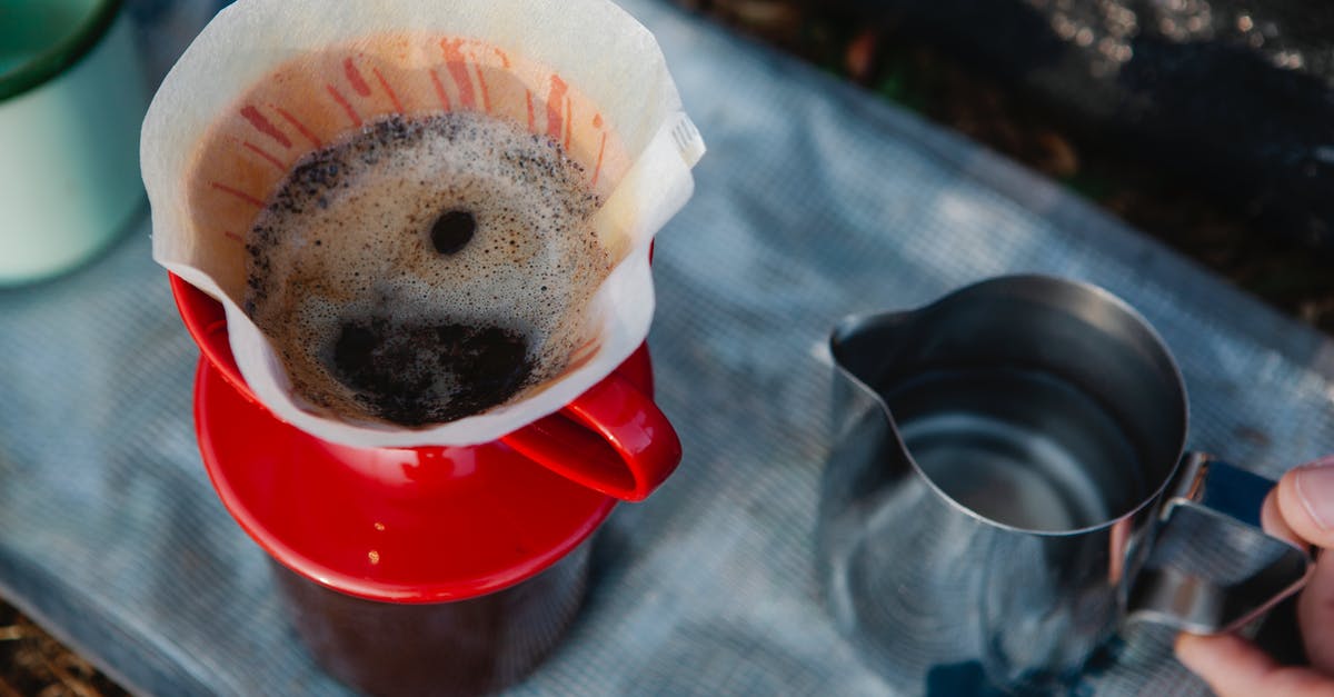 How to make a strong mug of instant Coffee? - Crop hiker preparing coffee in carafe on fabric