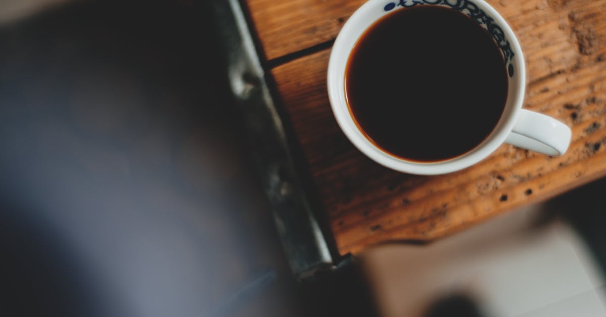 How to make a strong mug of instant Coffee? - From above of ceramic cup with ornament and aromatic strong coffee on shabby table