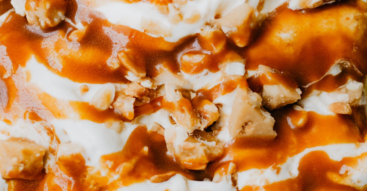 How to make caramel sauce for sundaes? - Close-up of Ice Cream with Caramel Sauce and Nuts on Top 