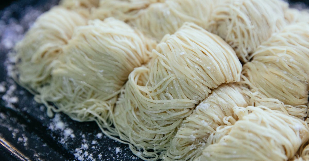 How to make Fresh Asian Noodle? [closed] - Homemade egg noodles collected in rolls and sprinkled with flour on black baking sheet