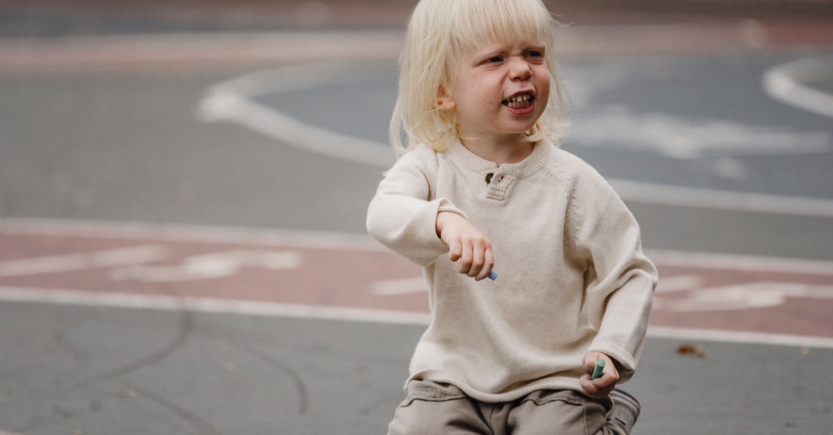 How to make ground almonds creamy? - Full length dissatisfied little girl with chalks in casual wear sitting on asphalt ground and looking away