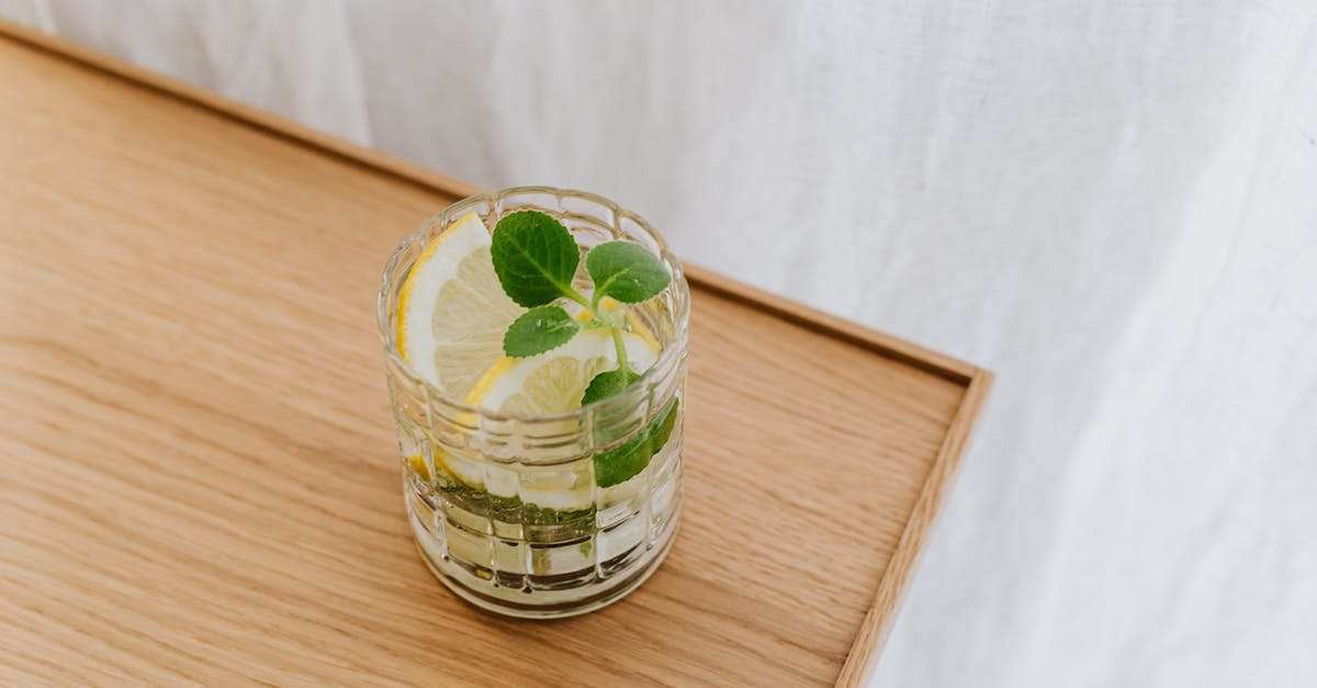 How to make mint syrup with minimum water? - From above faceted thick wall glass of cold exotic drink on wooden desktop