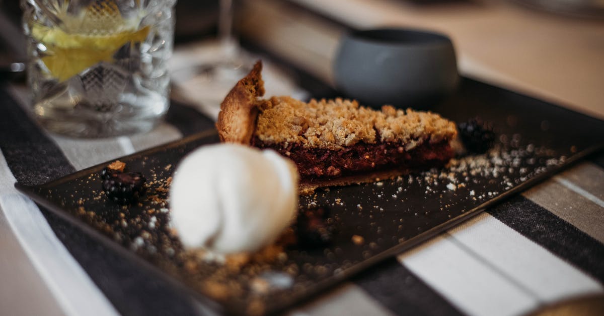 How to make pie filling which tastes like yogurt icecream? - Slice of tasty crumble pie with berry filling on plate with scoop of ice cream served on table in restaurant on blurred background