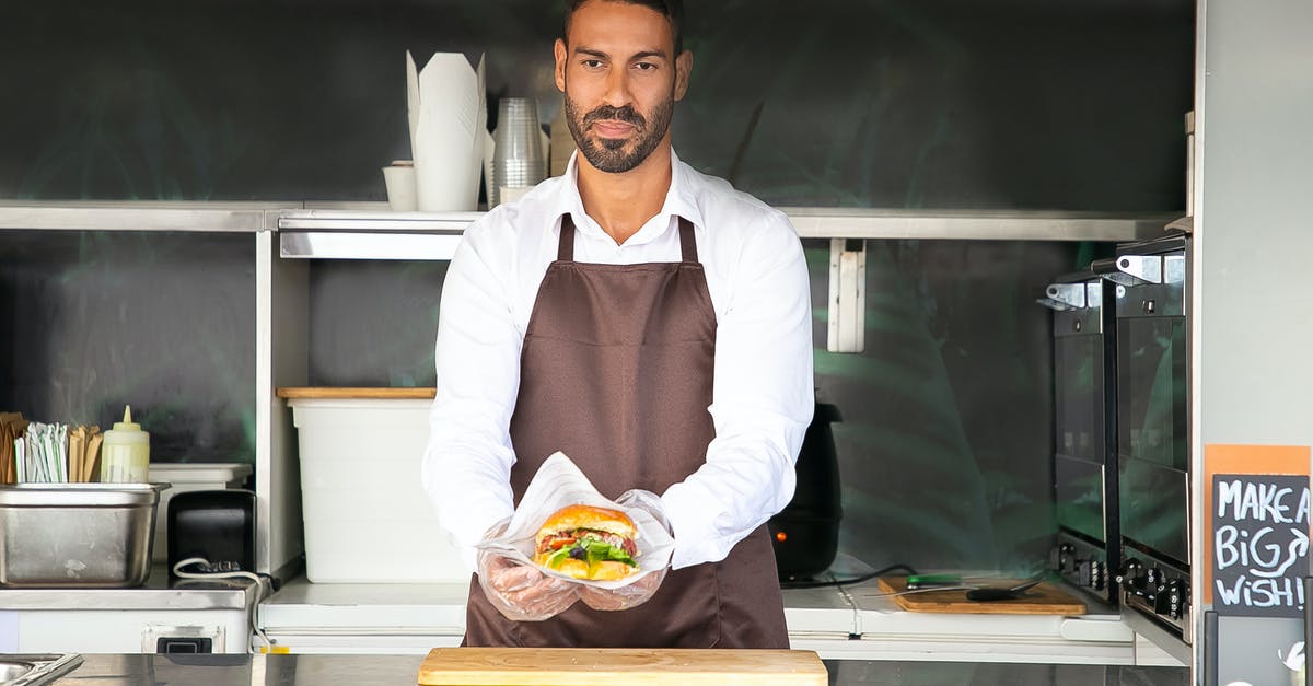 How to make professional style burger buns? - Young ethnic chef showing tasty burger in road cafe