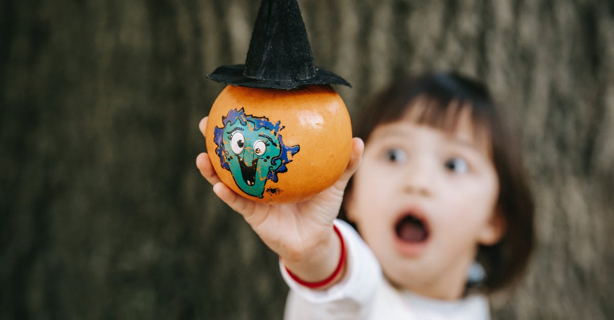 How to make Pumpkin Fries - Little girl with opened mouth in white outfit demonstrating pumpkin decorated and painted for Halloween