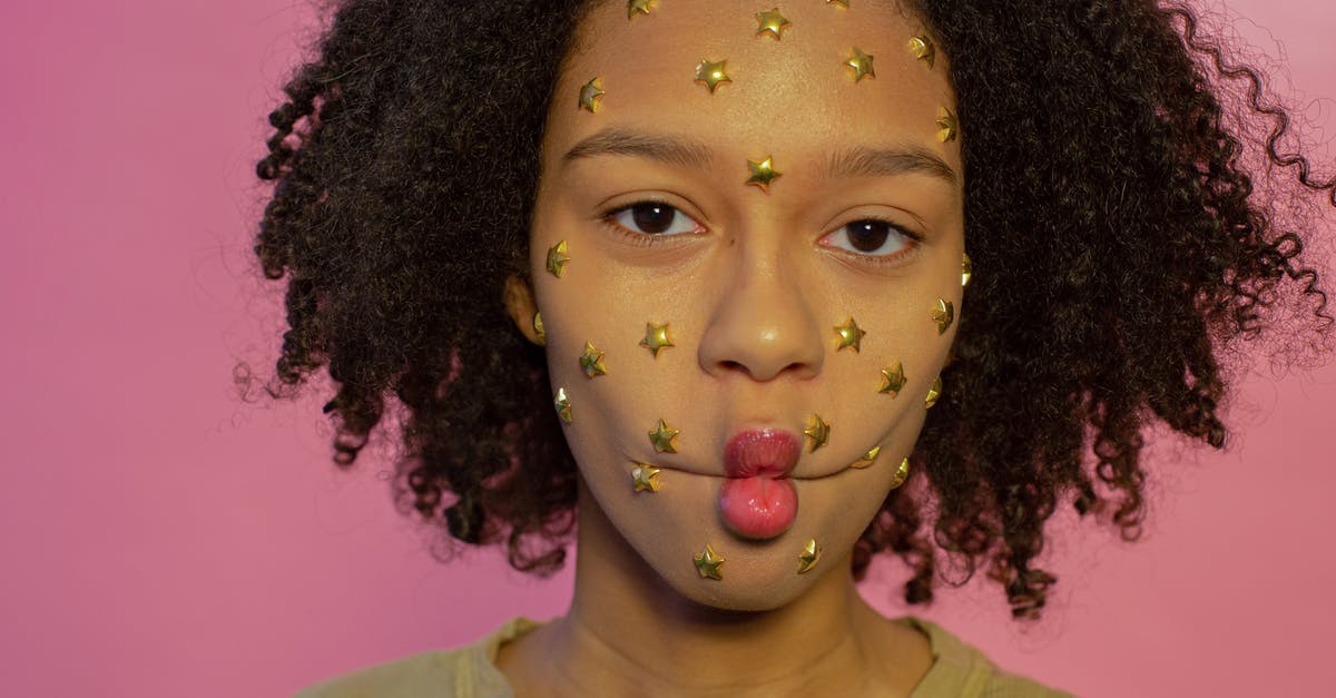 How to make saffron really color my risotto? - Young African American female with yellow star rhinestones on face looking at camera while making fish lips on pink background