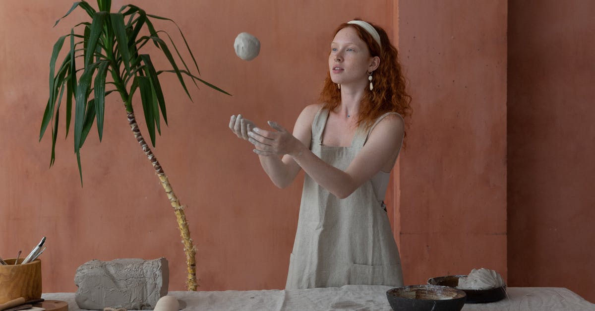 How to make soft popsicles - Young skilled female ceramist wearing light apron throwing clay ball while making ceramic products in modern workshop