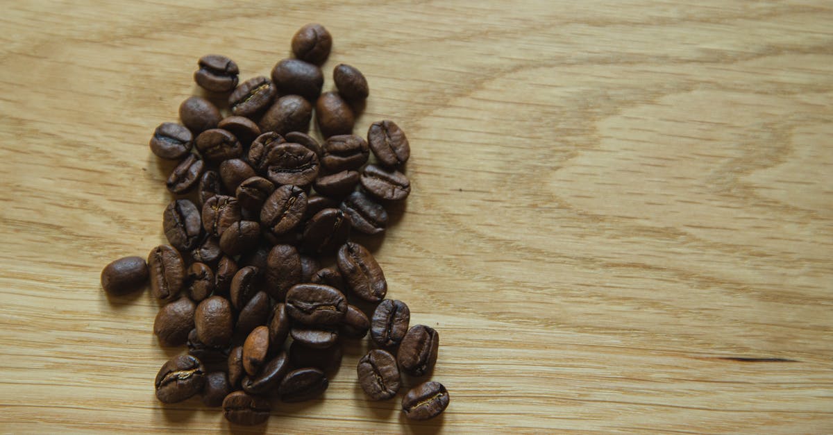 How to make specific taste more obvious in slow cooker - Top view of scattered coffee beans placed on wooden table before making coffee