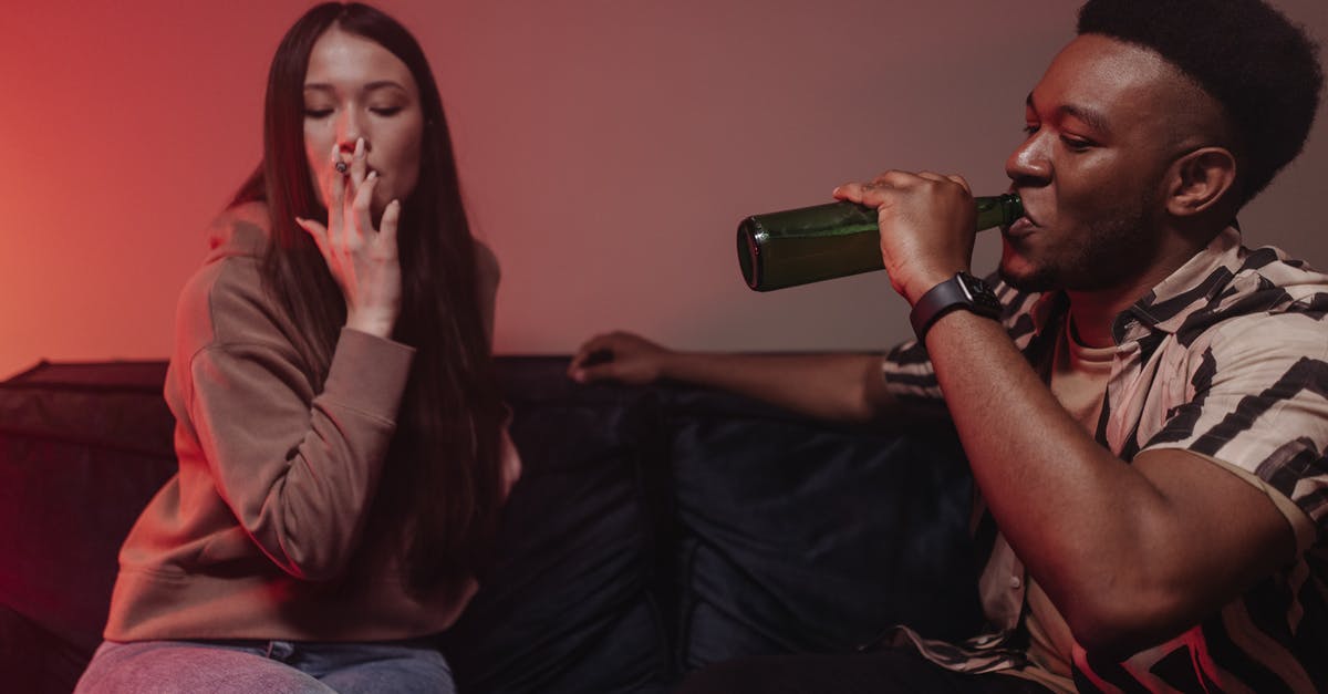 How to make the perfect root beer - Man in Brown Dress Shirt Drinking from Green Bottle