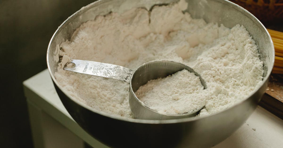 How to measure a cup of "solid" ingredient? - Bowl with flour and measuring cup in kitchen