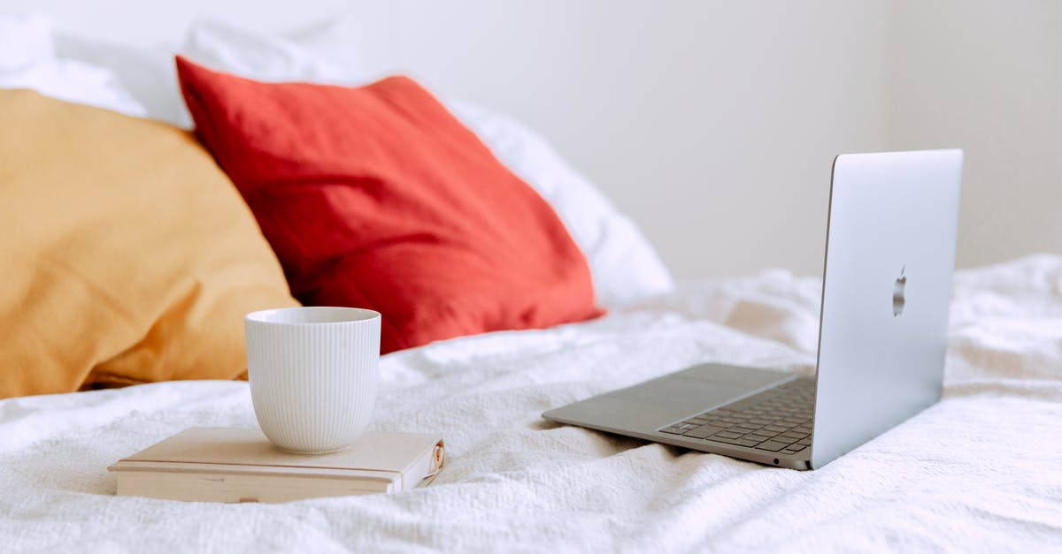 How to minimize splatter using an immersion blender? - Laptop and cup of coffee on notepad near pillows on bed at daytime