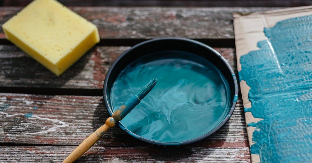 How to mix large amounts of sponge for bread? - From above of turquoise paint in bowl with brush placed on wooden board near cardboard and sponge during repair work